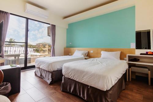 a hotel room with two beds and a large window at 98Inn in Xiaoliuqiu