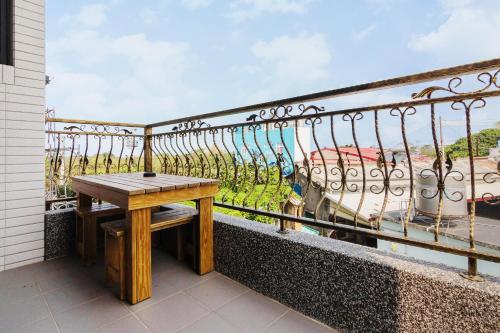a wooden bench sitting on a balcony with a view at 98Inn in Xiaoliuqiu