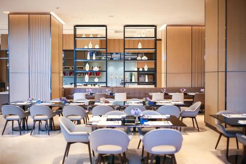 uma sala de jantar com mesas e cadeiras em Hyatt House Shanghai Hongqiao CBD em Xangai