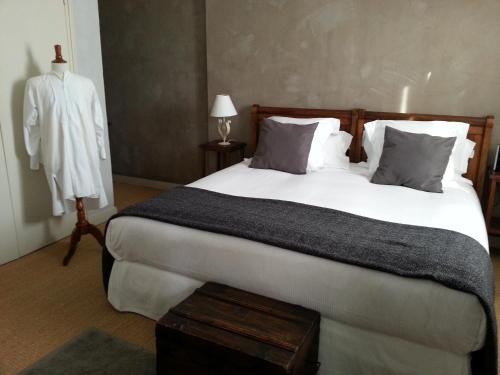 um quarto com uma grande cama branca e um roupão em MAISON DE MARQUAY-MAISON D'HOTES em Marquay