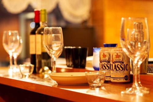 a table with wine glasses and bottles of wine at The COMFORIA in Sapporo