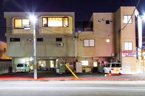 a building with two cars parked in a parking lot at The COMFORIA in Sapporo