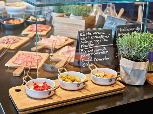 a buffet with bowls of food on a table at Grand Park Hotel Rovinj by Maistra Collection in Rovinj