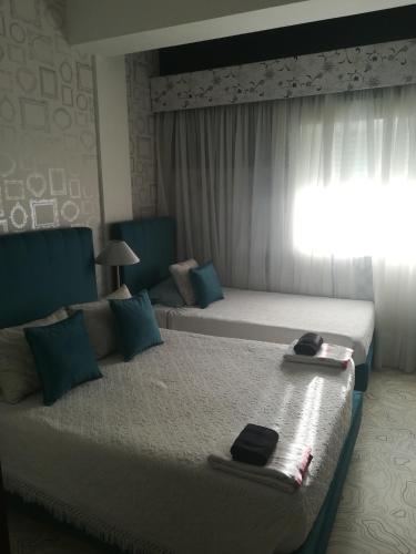 a hotel room with two beds with towels on them at Hotel Cristo Rei in Porto