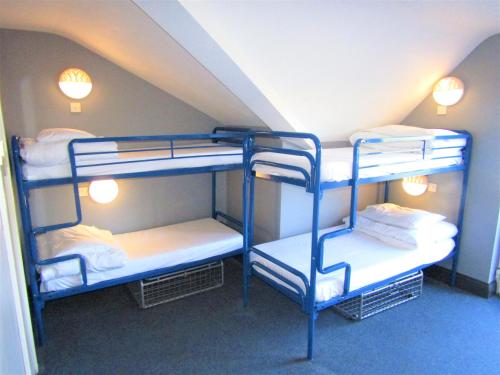 a room with three bunk beds in a attic at Sleepzone Hostel Galway City in Galway