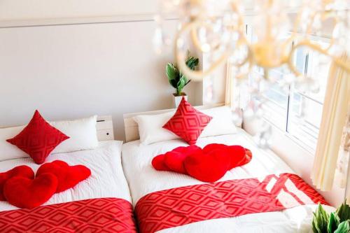 two beds with red pillows with hearts on them at LOVELY in Sapporo
