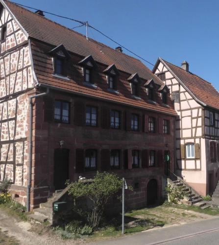 an old brick building on the side of a street at Chambre d'Hôtes chez Nadine Hamm in Weiterswiller