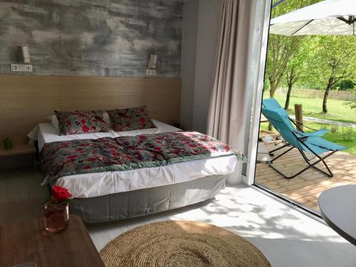 a bedroom with a bed and a sliding glass door at Cottage du garlai in Bressuire