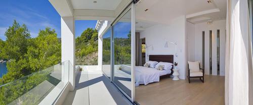 a bedroom with a view of a bed and a balcony at Luxury Seafront Villa My Dream with private pool, jacuzzi and staff at the beach on Brac island - Sumartin in Selca