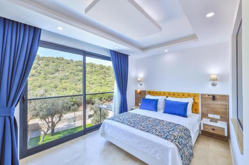 a bedroom with a bed and a large window at Villa Kas Bohem in Kaş