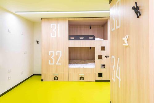 um quarto com um beliche e um piso amarelo em Hostel Le Hüb Grenoble em Grenoble