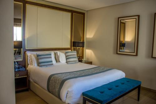 a bedroom with a large bed with a blue bench at La Cigale Tabarka in Tabarka