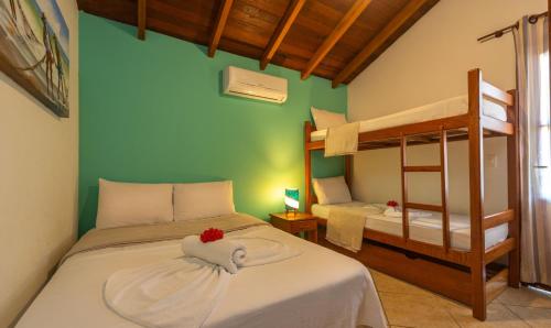 a bedroom with a bed and a bunk bed at Capoeira Village in Porto Seguro