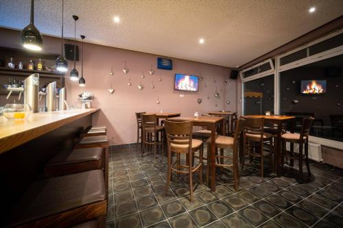 a bar with wooden bar stools in a restaurant at Anor Hotel & Conference Center Frankfurt Airport in Mörfelden-Walldorf