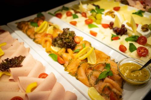 une table avec trois plateaux de différents types de denrées alimentaires dans l'établissement Anor Hotel & Conference Center Frankfurt Airport, à Mörfelden-Walldorf