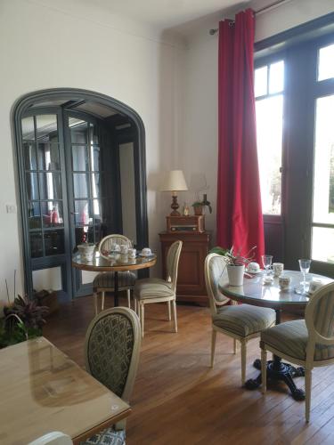 una sala da pranzo con 2 tavoli, sedie e uno specchio di Château de Champblanc a Cherves-de-Cognac