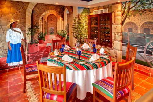 a table in a restaurant with a woman standing in the background at Occidental Costa Cancún - All Inclusive in Cancún