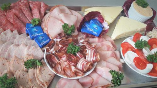 a tray of different types of meats and cheese at Hotel Schwarzer Adler in Pettneu am Arlberg
