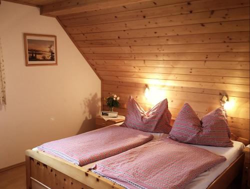 two beds in a room with a wooden ceiling at Zukaunighof in Diex