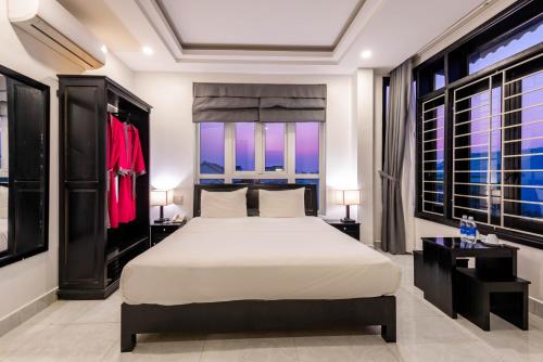 a bedroom with a bed and two windows at Flamingo Villa Homestay - Big Rooms with Balcony - Close to Hoi An Old Town 200m & Temple Bridge - Large Outside Pool for Sun Bathing in Hoi An