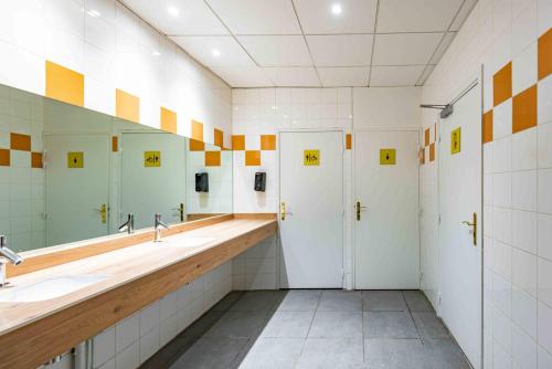 a bathroom with two sinks and a large mirror at Hostel Le Hüb Grenoble in Grenoble