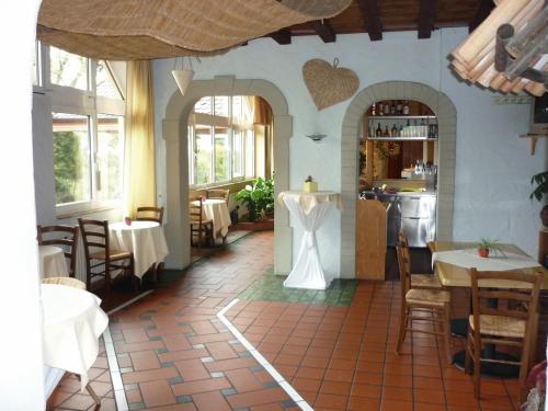 ein Restaurant mit Tischen und Stühlen und eine Küche in der Unterkunft Abakus-Hotel in Sindelfingen
