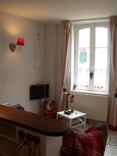 a living room with a bed and a window at Chambre d'hôtes - Dodo et tartines in Bayeux