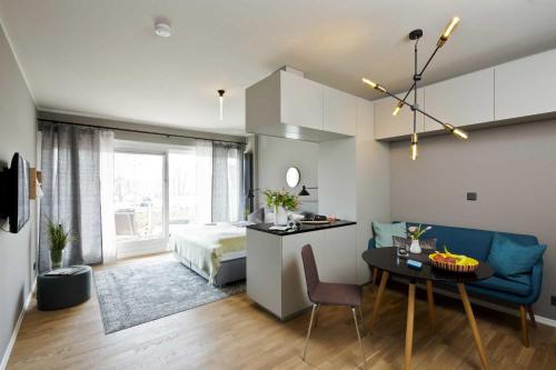 Design-Apartment an der Strandallee nur 50 Meter vom Strand في شاربوتس: غرفة بسرير وطاولة مع أريكة زرقاء