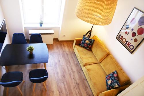 Classic apartments Pilsudskiego street في كراكوف: غرفة معيشة مع أريكة وطاولة