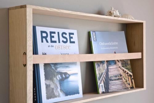 une étagère contenant des livres et des magazines dans l'établissement Bellevue Wohnung 2, à Scharbeutz