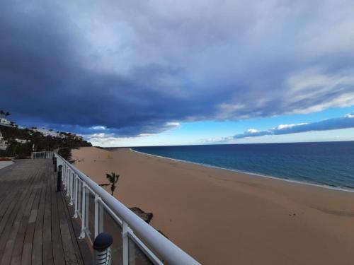 een uitzicht op het strand vanaf een pier bij XQ El Palacete in Morro del Jable