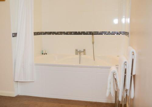 a white bathroom with a sink and a shower at King Charles Hotel in Gillingham