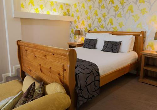 a bedroom with a bed and a chair in it at King Charles Hotel in Gillingham