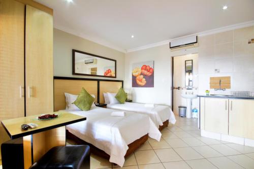 a hotel room with two beds and a kitchen at Seagull Lodge in Richards Bay