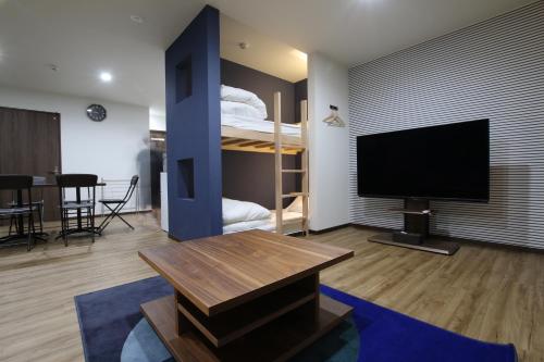 a living room with a television and a bunk bed at Tiz wan 岩屋あわじ in Awaji