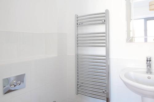 Baño blanco con aseo y lavamanos en Modern Oxford Apartment - Sleeps 4, en Oxford