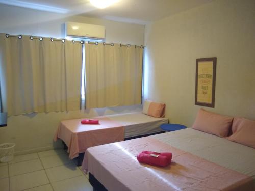 a room with two beds with red objects on them at Casa da Esquina Pousada in Recife