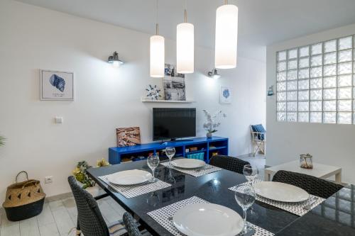 a dining room with a black table and chairs at Serenity by the Marina, Vilamoura in Quarteira