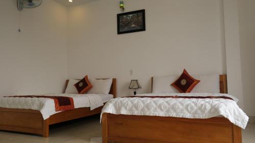 two beds sitting next to each other in a bedroom at Kh&aacute;ch sạn Hiệp Thạnh in Buon Ma Thuot