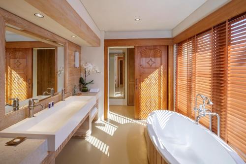 een badkamer met 2 wastafels en een bad bij Anantara Sir Bani Yas Island Al Yamm Villa Resort in Da‘sah