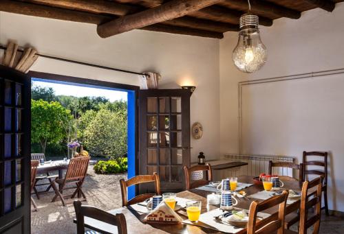 a dining room with a table and chairs and a window at Monte do Serrado de Baixo - T4 in Évora