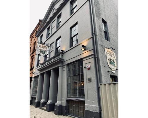 a building on a street next to a sidewalk at Babbity Bowsters in Glasgow