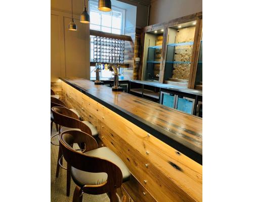 a kitchen with wooden cabinets and wooden tables at Babbity Bowsters in Glasgow