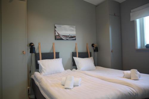 a bedroom with a large bed with white sheets and pillows at Tofta Resort in Tofta