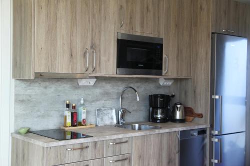 a kitchen with wooden cabinets and a sink and a refrigerator at Tofta Resort in Tofta