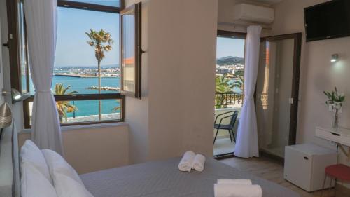 a bedroom with a bed with a view of the ocean at Faros Rooms & Suites in Rethymno Town