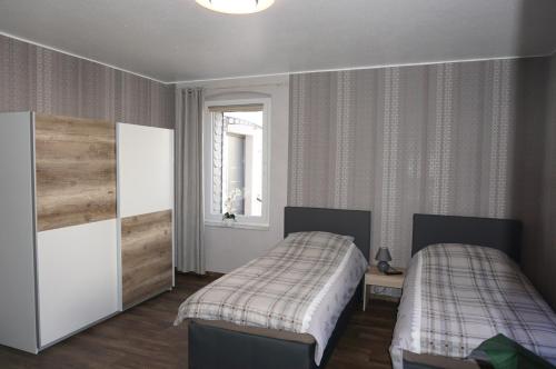 1 dormitorio con 2 camas y ventana en Super Erdgeschosswohnung, en Königslutter am Elm