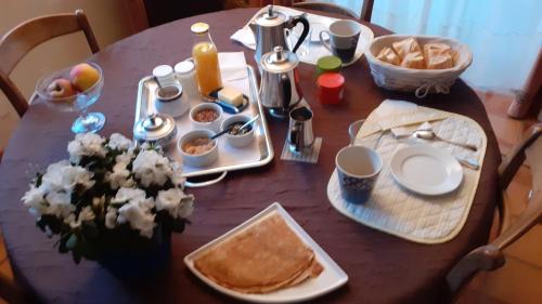 - une table en bois avec des aliments pour le petit-déjeuner dans l'établissement Mer et campagne, à Ploemeur