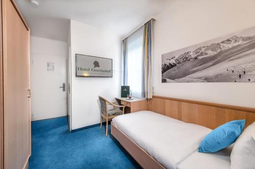 a hotel room with a bed and a desk at Hotel Goethehof in Bad Gastein