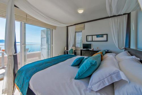 una camera da letto con un grande letto con cuscini blu di Naša Kuća Bed & Breakfast - Adults Only a Brist